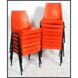 A set of 12 retro 1970's orange plastic and tubular metal stacking chairs. Raised on ebonised