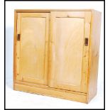 A 20th century industial / utility pine school cupboard / storage unit having two large twin sliding