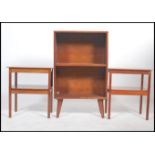 A 1960's retro teak two shelf bookcase raised on tapered angular legs together with a pair of teak