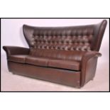 A retro mid 20th century batwing 3 seat sofa settee. In the manner of G-Plan being raised on castors