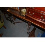 A 1930's oak barley twist draw leaf dining table being raised on barley twist legs with pad feet