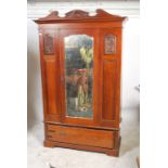 An Edwardian mahogany Art Nouveau wardrobe having a plinth drawer base with shaped legs having