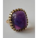 A 1950's hallmarked 9ct gold and amethyst ring set with a large amethyst cabochon in a stylised