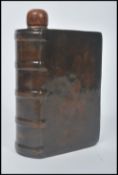 An unusual Royal Doulton earthenware spirit flask, in the form of a leather book, entitled The
