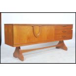 A good 1970's teak wood inverted  sideboard of Danish influence raised on tapering legs with a