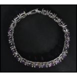 A sterling silver panel bracelet set with amethyst stones having fold over clasp. Weighs 29 grams.