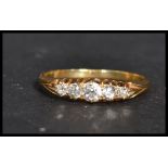 An 18 carat gold three stone diamond ring. Weighs 2.5 grams size R.