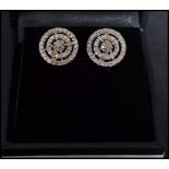A pair of 9ct gold and diamond earring of layered roundel form complete in presentation box.