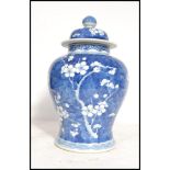 An early 20th century Chinese blue and white ceramic lidded vase decorated in the prunus pattern