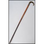 A 19th century Victorian walking stick cane having a tapering wooden shaft with shaped horn