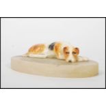 An early 20th century Royal Doulton figurine ashtray featuring a reclining dog on an onyx / marble