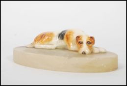 An early 20th century Royal Doulton figurine ashtray featuring a reclining dog on an onyx / marble