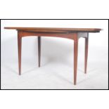 A mid century teak wood Danish inspired dining table raised on tapering supports with extending