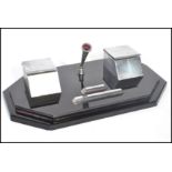 A vintage early 20th century Art Deco twin capstan inkwell desk tidy of black glass construction