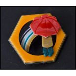 Léa Stein b1936: A vintage 20th century compressed plastic brooch in the form of a rainbow with girl