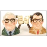 A Royal Doulton pair of Small Character Jugs: The Two Ronnies comprising Ronnie Barker D7114 and