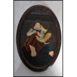 A 20th century painting on glass of a boy and girl knitting set to an oval frame. Measures 30cm