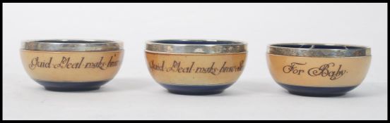 A group of four Royal Doulton bowls having silver hallmarked rims. One bearing inscription For