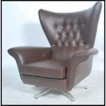 A retro mid 20th century batwing swivel armchair / chair. In the manner of G-Plan being raised on