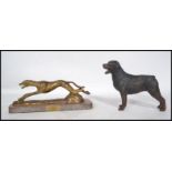 A vintage 20th century painted cast iron figurine of a Rottweiler dog along with a brass figurine of