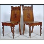 A pair of 19th century Victorian oak hall chairs being raised on carved tapering legs with panel