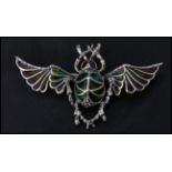 A sterling silver and plique a jour brooch in the form of a flying scarab beetle. Pin to verso.