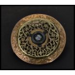 An unusual gilt filigree brooch made from a pocket watch movement having a central white stone.