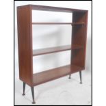 A mid century retro teak wood bookcase cabinet having open shelves and raised on dansette style