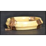 An early 20th century 9ct gold  mounted hinged ivory bangle
