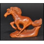 An Oriental Japanese netsuke carved in the form of a horse. Signed to base.