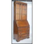 A vintage 1930's Art Deco oak bureau bookcase, with glazed upper doors, over a fall front with fully