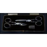 A silver hallmarked cased sewing set consisting of two pairs of silver hallmarked scissors and a