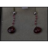 A pair of 9ct gold and garnet stone drop earrings complete in presentation box.