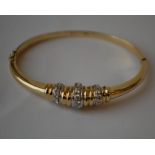 An 18ct gold and diamond bangle bracelet with white gold set round cut diamonds. Diamonds approx
