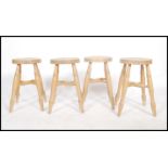 A set of four English country style beech wood stools having a ' x ' frame stretcher and turned