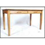 An early 20th century industrial office beech wood AirMinistry style desk raised on four square legs