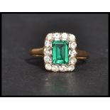 A vintage 20th century hallmarked 9ct gold green and white stone ring. The central emerald cut green