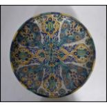A  believed Persian tin glazed pottery wall charger - large bowl being handpainted with geometric