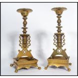 A pair of 19th century Victorian cast brass candlesticks raised on square gallery bases on four ball