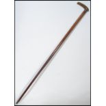 A 19th century Victorian walking stick cane having a tapering wooden shaft with shaped handle. The