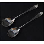 A pair of early 20th century silver hallmarked salad servers / serving spoons being hallmarked for