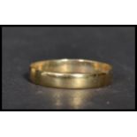 A hallmarked 9ct gold band ring of plain form. Size P.