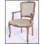 A 20th century French fauteuil beech wood armchair raised on reeded and shaped legs with shield back