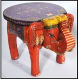 An unusual 20th century handpainted elephant stool in vivid colours having a circular seat above.