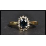A vintage 20th century hallmarked 9ct gold diamond and sapphire ring. The central blue stone adorned