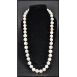 A vintage freshwater pearl necklace strand. The pearls of varying form but similar size. Claw clasp.