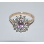 A hallmarked 9ct gold cluster ring set with a central purple stone surrounded by a twin halo of CZ.