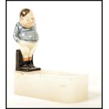 A Royal Doulton figurine pipe holder having a figure of Fat Boy on an onxy base. The base signed