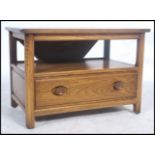 A 20th century Ercol ' Golden Dawn ' elm wood side table unit having a drop leaf table top with