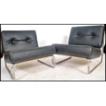 A pair of retro 1970's retro black vinyl and tubular chrome open armchairs. Each of simple form with